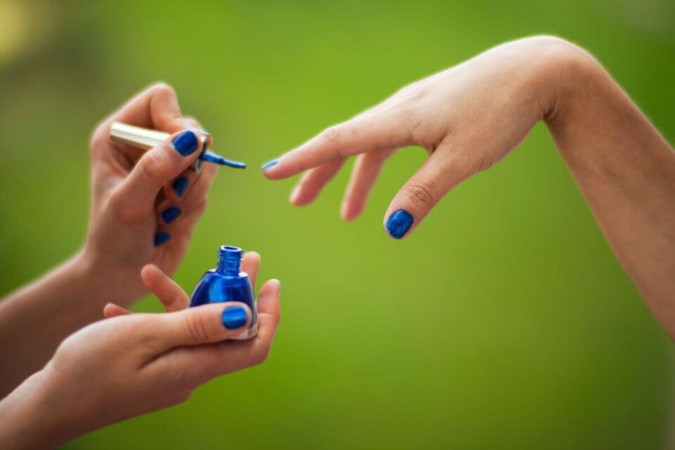 niebieskie paznokcie nakładanie niebieskiego lakieru w powietrzu na płytkę paznokcia